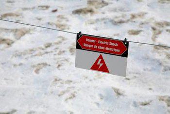 A sign on the rope in front of snow.