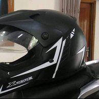 The helmet is on top of the motorcycle.