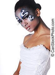 A woman with face paint and a white dress.