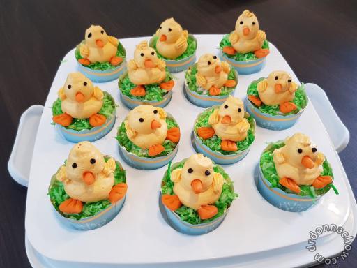 Cupcakes decorated like ducks and carrots on a plate