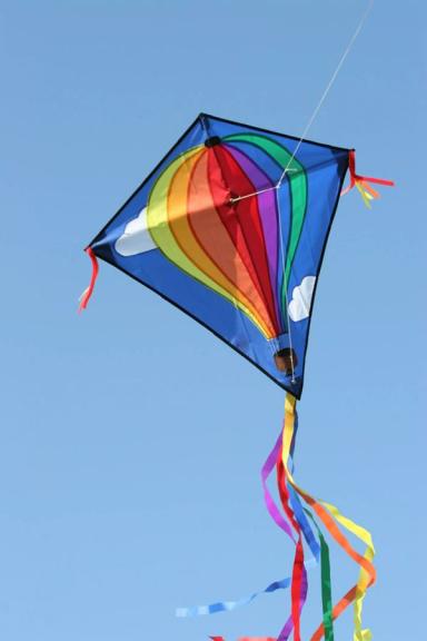 A kite with rainbows flying in the sky.