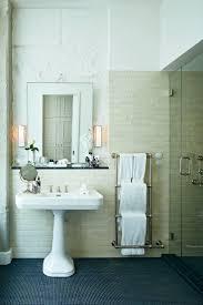 A bathroom with a sink, mirror and towel rack.